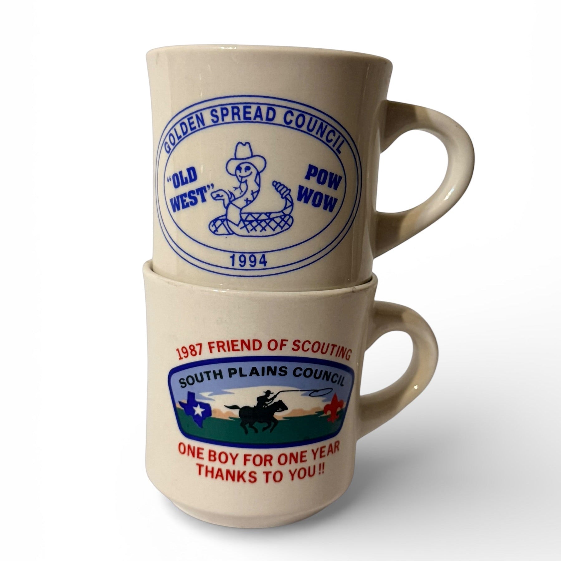 Two ceramic mugs with vintage scout-themed designs stacked on a white background
