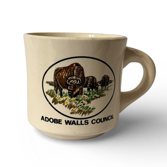 Beige mug with bison design and 'Adobe Walls Council' text on a white background